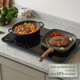Induction cooktop with pot and pan on a kitchen counter, featuring cooking food.